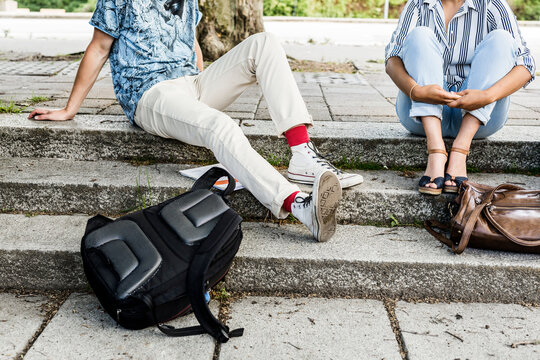 Students sitting on stairs outside library during study session.