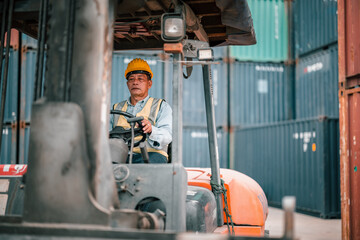 Fototapeta na wymiar Senior container controllers navigate and drive folklift to transfer, deliver and drop-off merchandise. An equitable work environment in which employees of various ages feel included and valued.