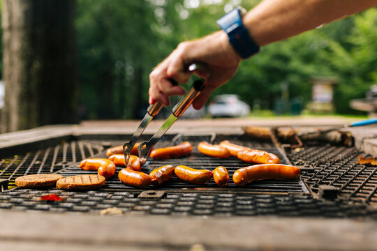 Close up of mans hand grilling food in forest