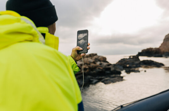 Man using smart phone at coastline