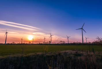 Obraz premium Windräder bei Sonnenaufgang und blauem Himmel
