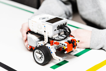 Teen girl student with diy robot on stem education class.Teen scientist working on new project.Stem education Learning To Program Robot Vehicle. © ARVD73