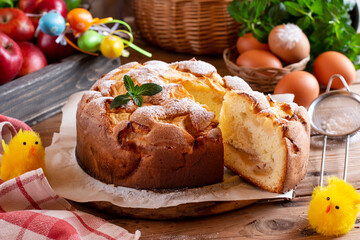 Pear and apple pie with nuts and mascarpone, colorful Easter eggs on a table. Sweet bread