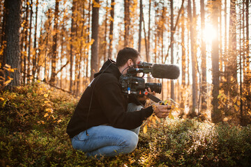 Man filming forest in autumn