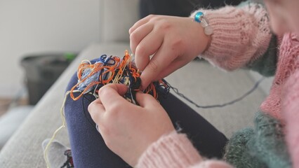 Cute Creative Caucasian Girl Trying to Untangle Hank Skein of Yarn