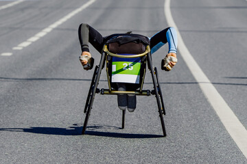 para athlete in wheelchair riding road marathon race, movement uphill overpass, para athletics...