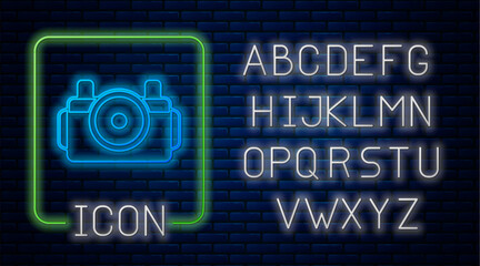 Glowing neon Photo camera for diver icon isolated on brick wall background. Foto camera icon. Diving underwater equipment. Neon light alphabet. Vector