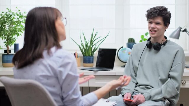 Woman social worker, mentor interviewing, talking to young male in office