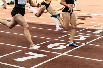 group female athlete crosses finish line sprint race track stadium, summer athletics championships