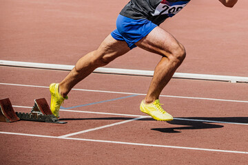 legs sprinter runner start from starting blocks running in track, summer athletics championships