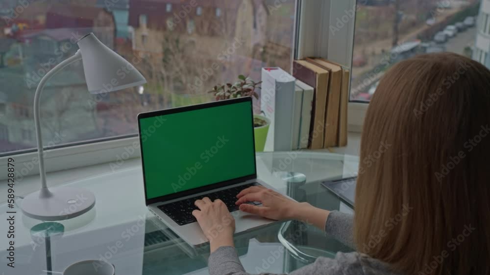 Aufkleber entrepreneur sitting at workplace typing on keyboard laptop with green display workspace with big wi