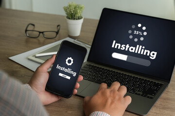 man installing Software Update On Mobile Phone And Laptop digital technology communication