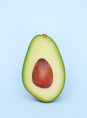 avocado cut in half on a light blue background