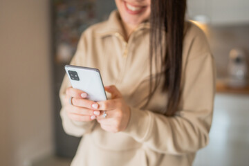 One young woman caucasian using mobile phone at home and smiling, using technology modern lifestyle concept 