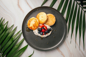 Cottage cheese syrniki pancakes with cream and berries