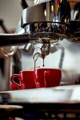 Preparation of espresso in a coffee machine. A drop of coffee falls into the cup