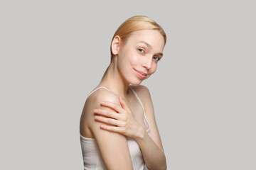 Attractive blonde woman smiling isolated on grey background. Beauty, cosmetics, skincare