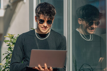 young man with laptop on the terrace or street outdoors