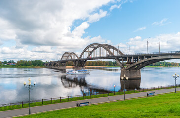 Fototapeta na wymiar Rybinsk, Russia. View of the Rybinsk road bridge with a motor ship moving along the Volga River.