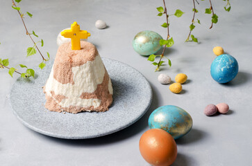 Easter attributes. Painted eggs, Easter cottage cheese zebra on a plate on a light background