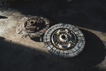 Clutch - new vs old part- old extremely torn out, garage shop, car repair concept. High quality photo