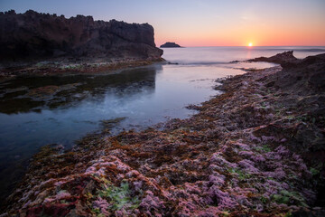 Sunrise from a rocky area in a cove of Cabo de Palos, in Cartagena, Region of Murcia, Spain