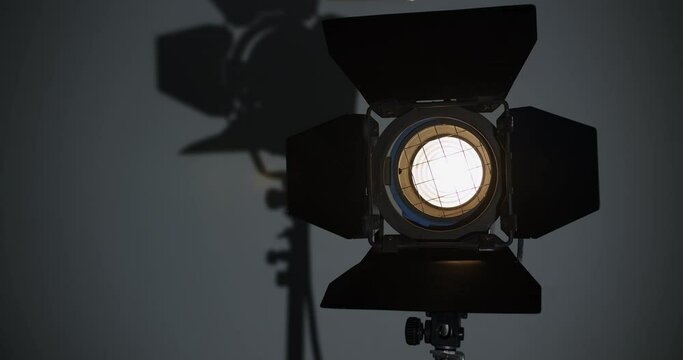 the lighting device in the video studio is set to work the searchlight is not turned on at first and is in the shadows, then it turns on.