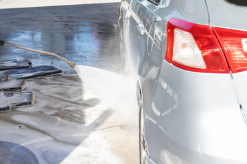 contactless car wash, car washer washes the car from a pressurized hose