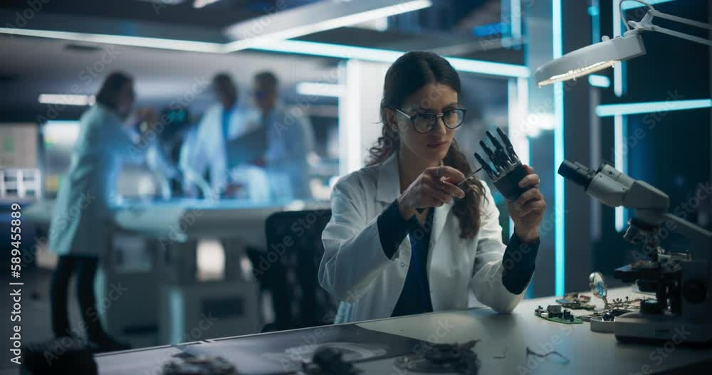 Poster Rack Focus Switching from a Female Engineer Fixing a Bionic Hand Component to Industrial Robotics Specialists in Lab Coats Working on a Mobile AI Robot in a Tech Factory Facility