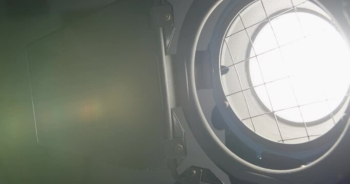 Video studio Fresnel lens spotlight on black background. lights slowly turn on and off. Close up.