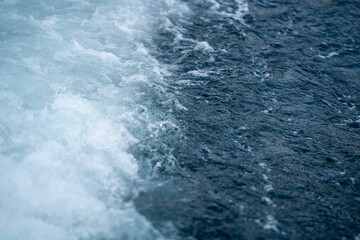 Fototapeta na wymiar Powerful white foamy wave crashing into the deep blue ocean