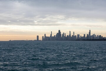 Fototapeta premium Beautiful shot of the silhouette of the Chicago skyline across the water at sunrise