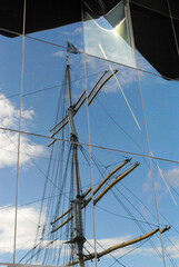 Reflection of Masts and Rigging On Old Sailing Ship in Glass Wall 