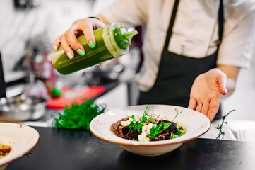 professional chef's hands cooking beetroot salad with feta cheese in a restaurant kitchen