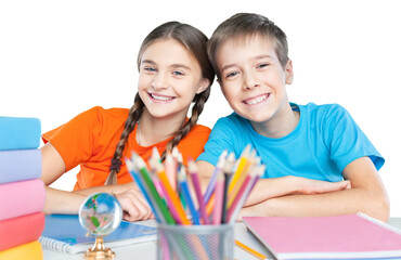 Happy children sitting by the table during lesson