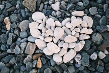 a heart made of white stones was laid out on the pebble beach