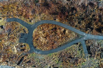 Aerial shot of a river flowing through the mountains by the road.