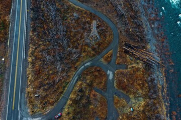 Aerial shot of a river flowing through the mountains by the road.