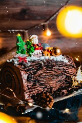Vertical shot of a decorative chocolate Christmas cake with brown icing and holiday toppings