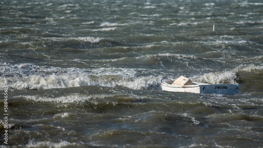 Wall mural Small Wooden Rowing Boat on the shallow water of splashing sea waves