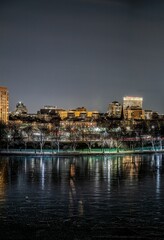 Obraz premium a city lit up at night with a bridge in the foreground