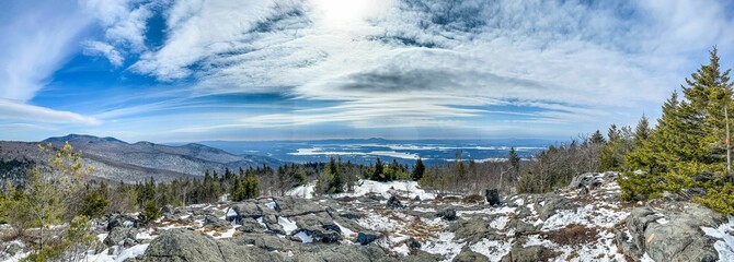 a view of snow covered mountains with a few trees on the ground