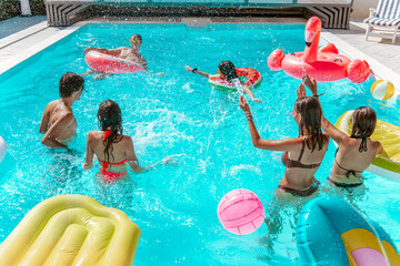 Group of friend play together in the swimming pool