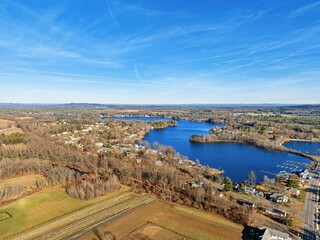 Aerial view of a city, fields, trees and a lake in a sunny day