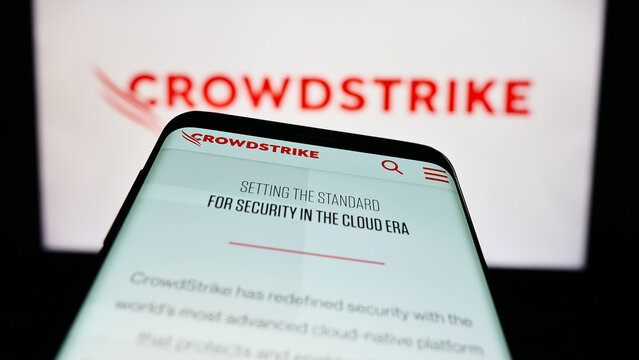 Stuttgart, Germany - 03-31-2023: Mobile phone with website of cybersecurity company CrowdStrike Holdings Inc. on screen in front of logo. Focus on top-left of phone display.