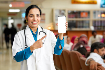 Indian female doctor showing smartphone screen.