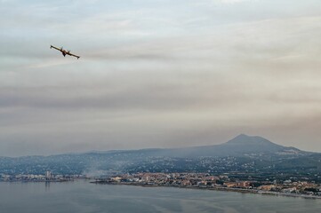 Fototapeta na wymiar Firefighting plane during the forest fire near the sea coast in Alicante, Spain