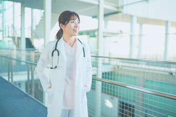 病院内を歩く白衣を着た女性医療従事者