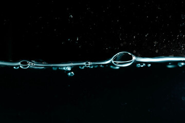 Water surface with bubbles on black background