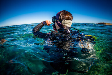Scuba Diver Checks Dive Computer on Ocean Surface